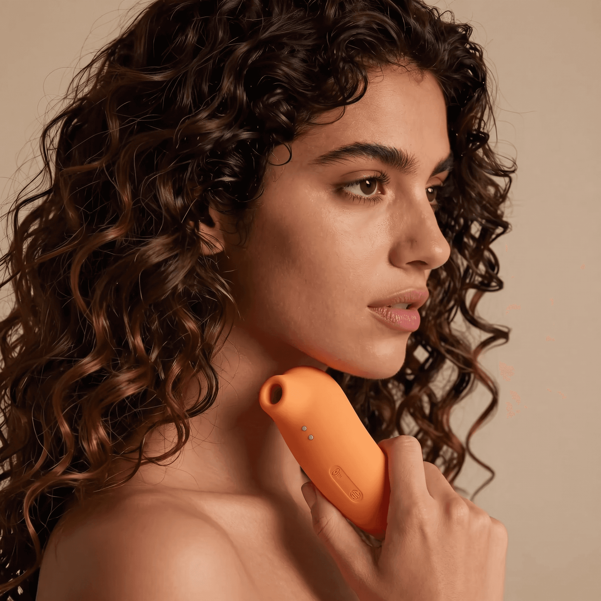 A woman in profile resting the air-pulse sucker against her neck